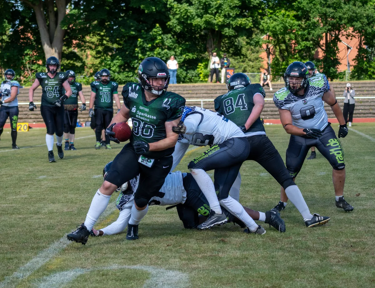 Ein Raptors-Runningback setzt sich mit dem Ball gegen einen Tackle durch